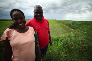 A husband joins his wife's enterprise of rice farming near Mbeya, Tanzania.